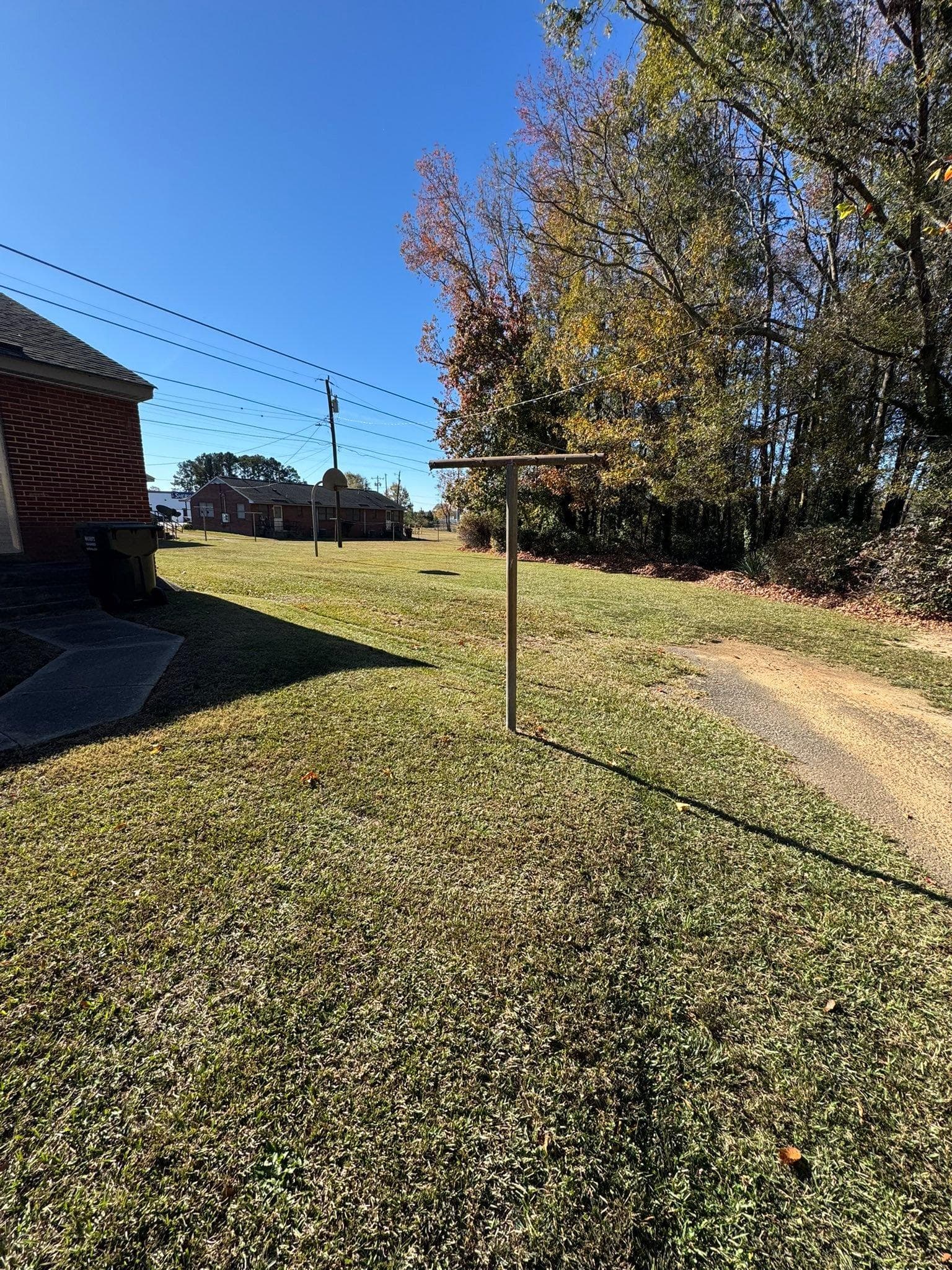 Newly rebuilt backyard with sod, shrubs, and a stone path